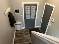 a hallway with a gray door and a coat hanger