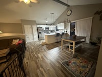 a kitchen and living room with hardwood floors and a ceiling fan