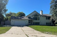 a home with a driveway and grass in front of it
